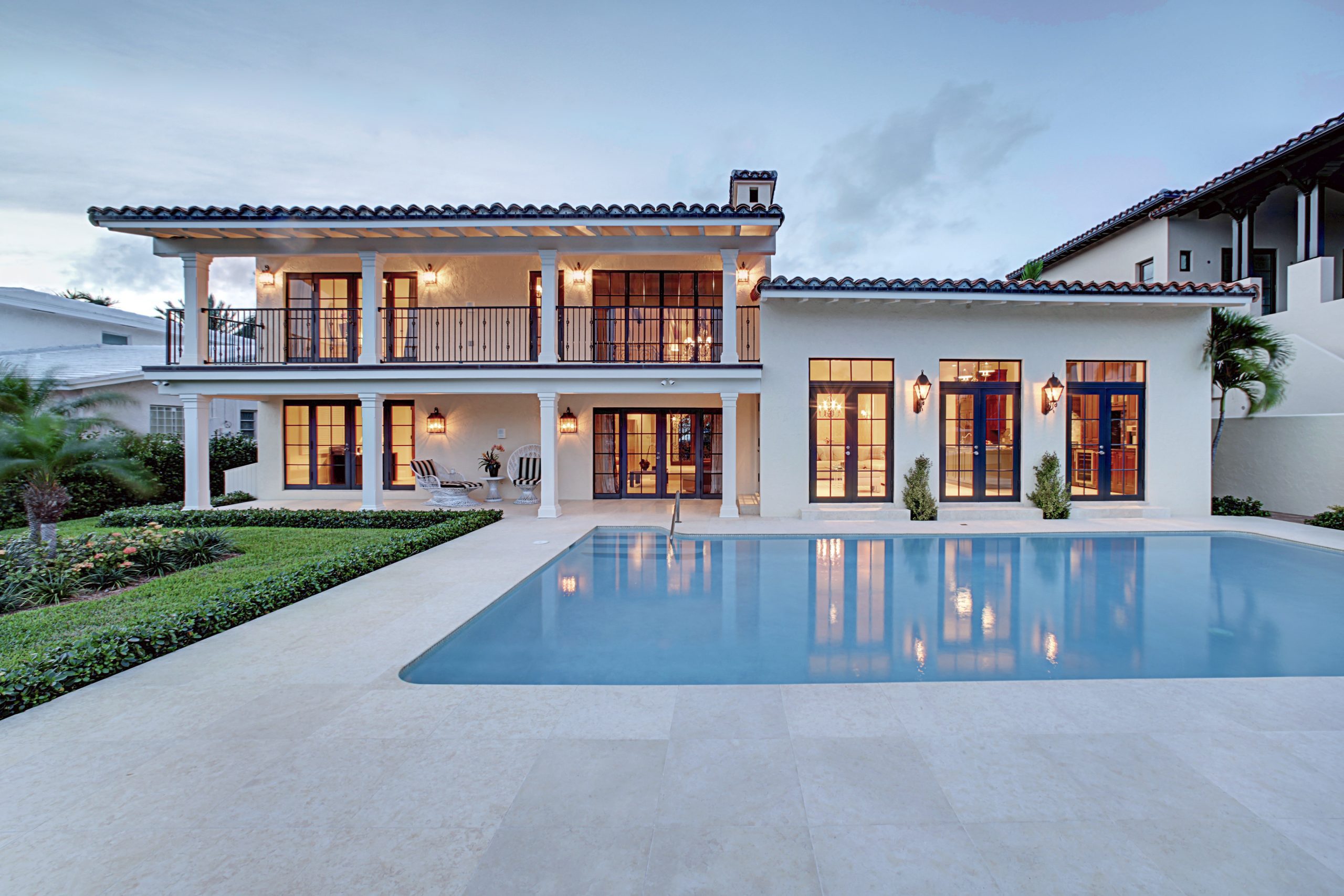 Spectacular Backyard Swimming Pool Designer home. Beautiful Exterior of New Home at Twilight.