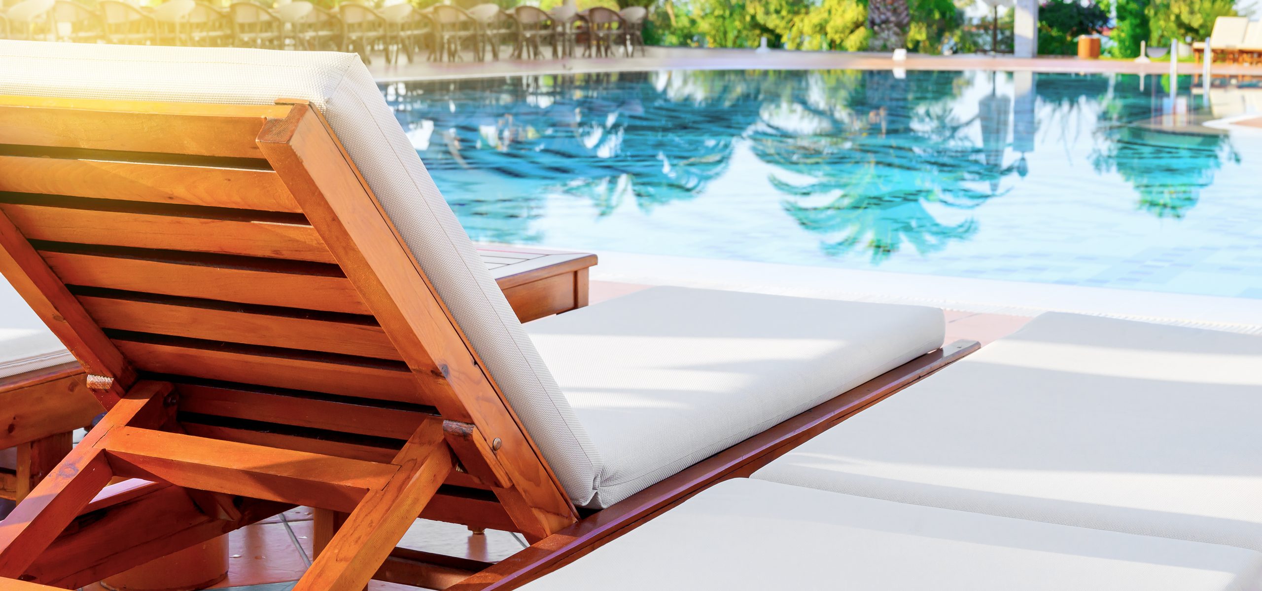 Deck chair and swimming pool in luxury resort